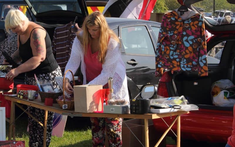 Two women preparing their items at car boot sales_Places to Sell Clothes for Cash in the UK Content Image UK