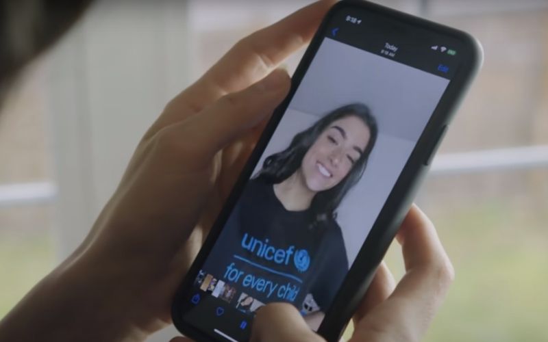 Image of two hands holding a smart phone showing an image of a woman