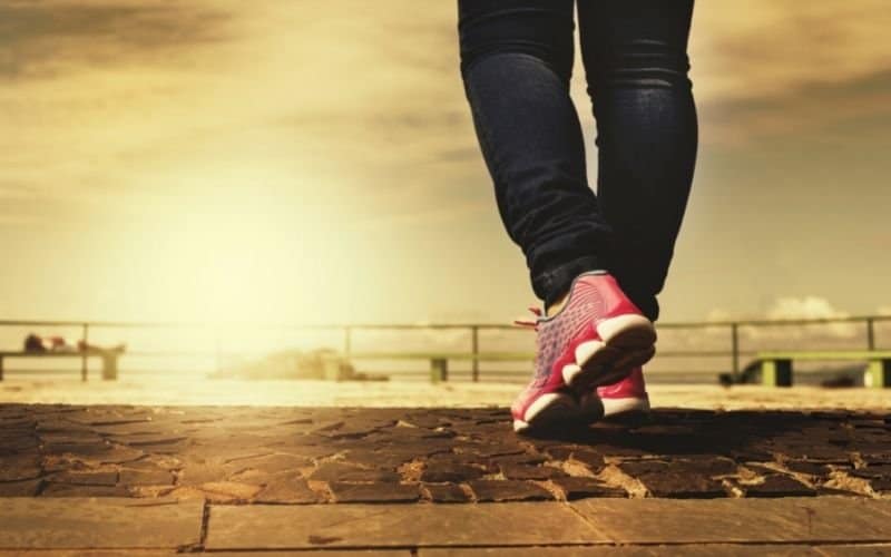 Photo of a pair of leg walking towards the setting sun