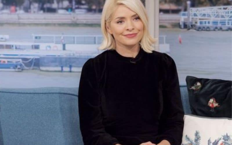 A photo of Holly Willoughby sitting in a sofa in black dress