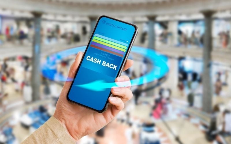 Image showing a hand holding a mobile phone that shows the word cashback