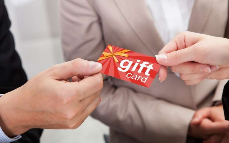 businessperson giving gift card to other businessperson