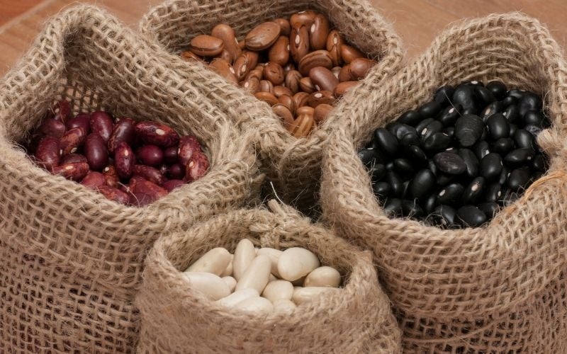 Photo of four different beans in small sacks