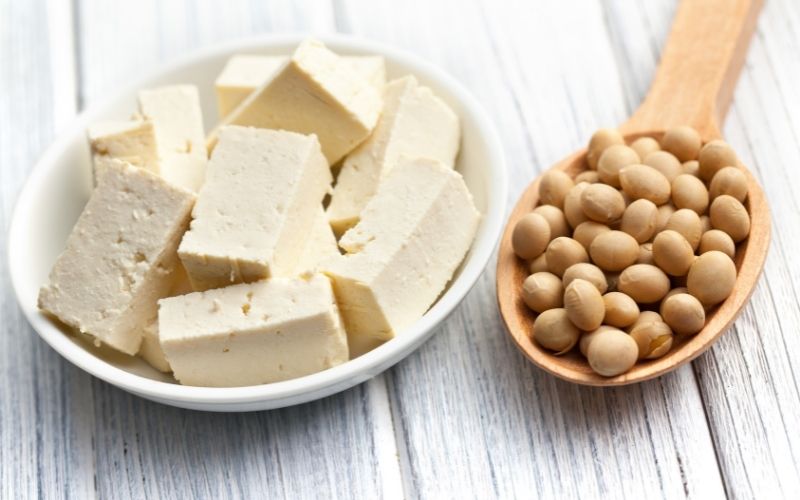 Photo of a plate filled with tofu and a wooden spoon filled with soy beans