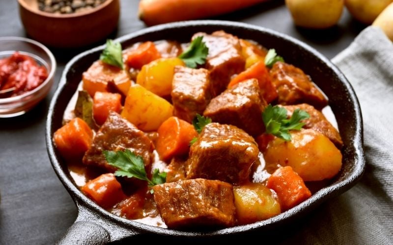 Photo of meat and vegetables with sauce in a pans