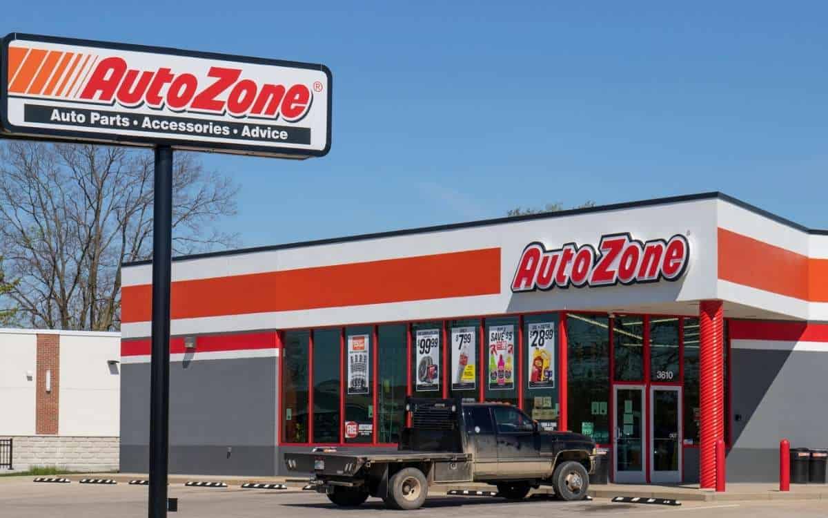 Image showing Auzone outlet by the road with a signboard and a vehicle at the front