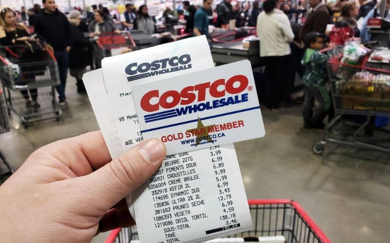 Photo of a hand holding a Costco membership card with receipt inside the supermarket