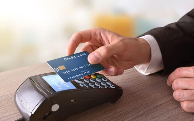 Image showing a hand holding a credit card over a scanner