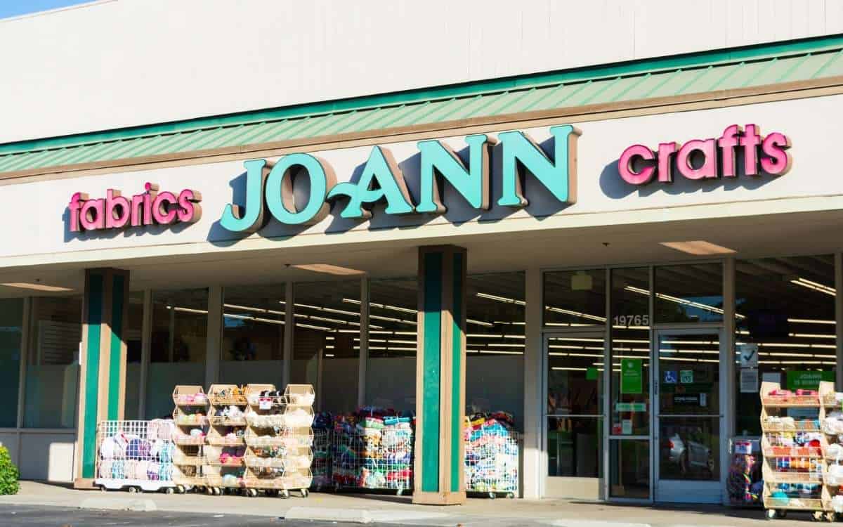 Photo of a large store with the name Joann above the main entrance with many items in front of the building