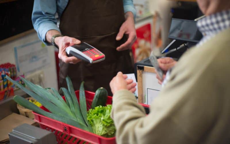 A person paying his groceries in using a debit card