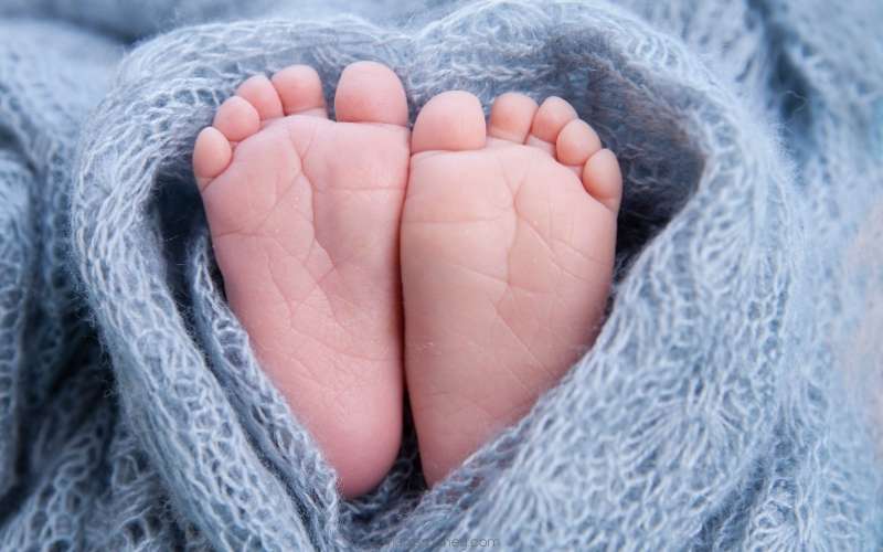 Picture of two baby feet wrapped in a blue blanket