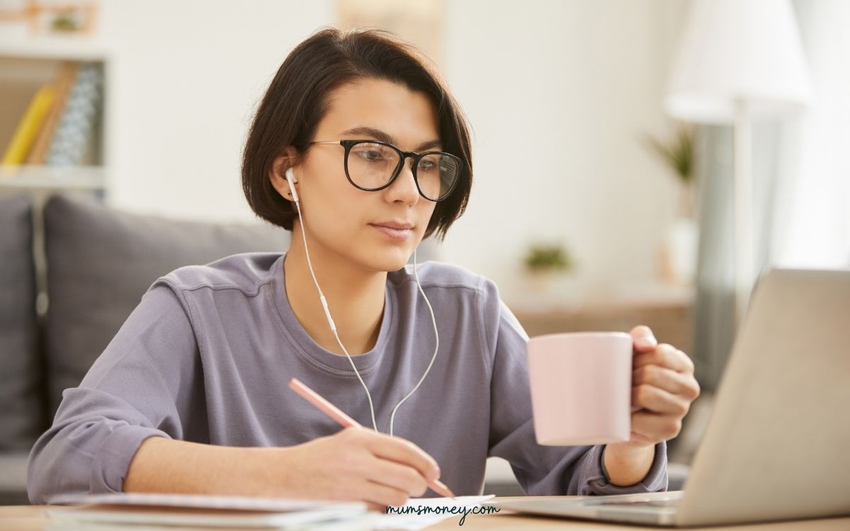 busy young female transcriptionist sitting at desk and making notes