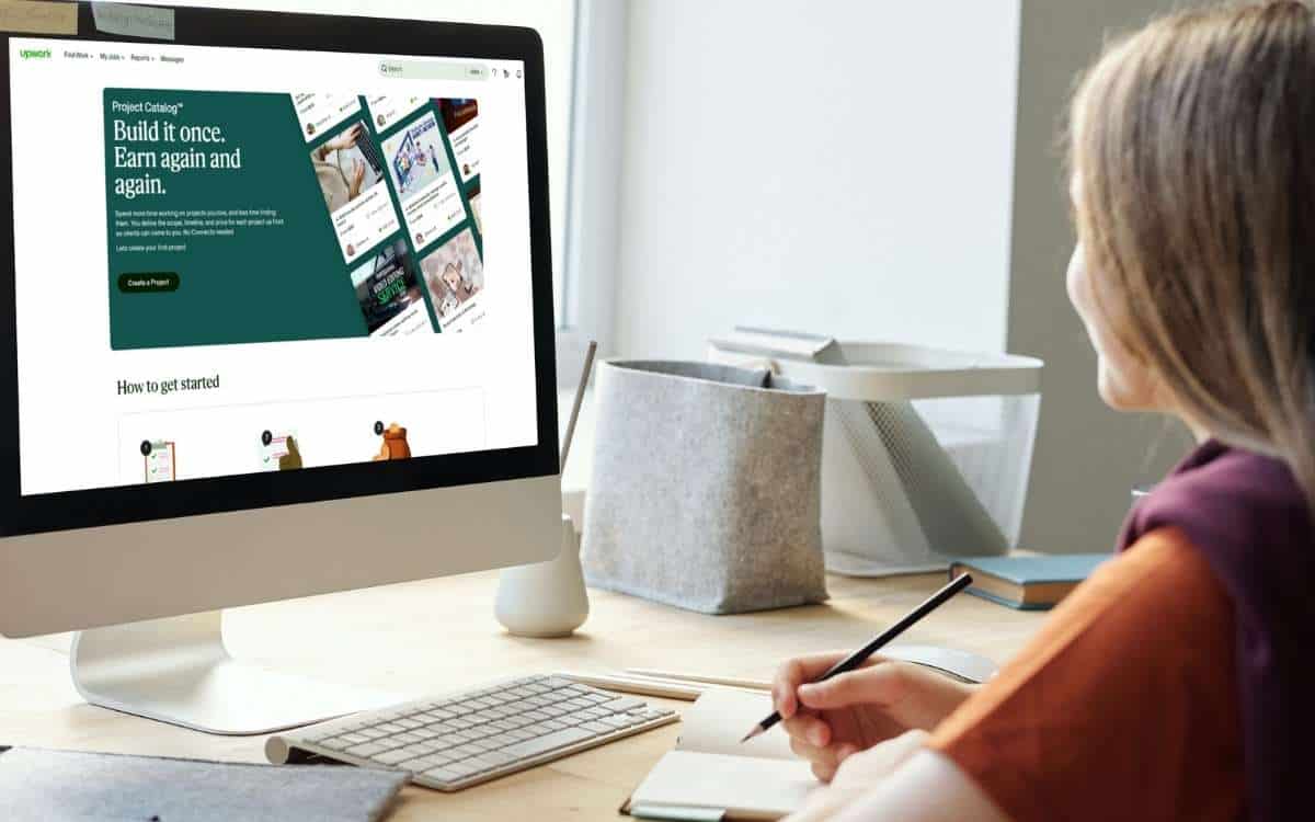 Image of aa woman in front of desktop with Upwork website on the monitor