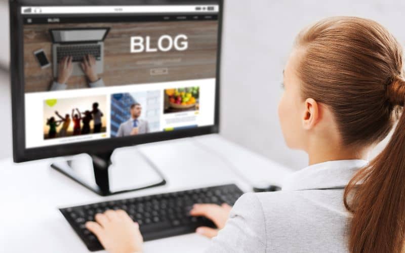 a young woman about 13 year old in front of a computer doing some blogging to make money 