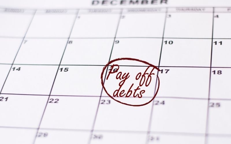 image of a planner with the words Pay Off Debts in red color written on it