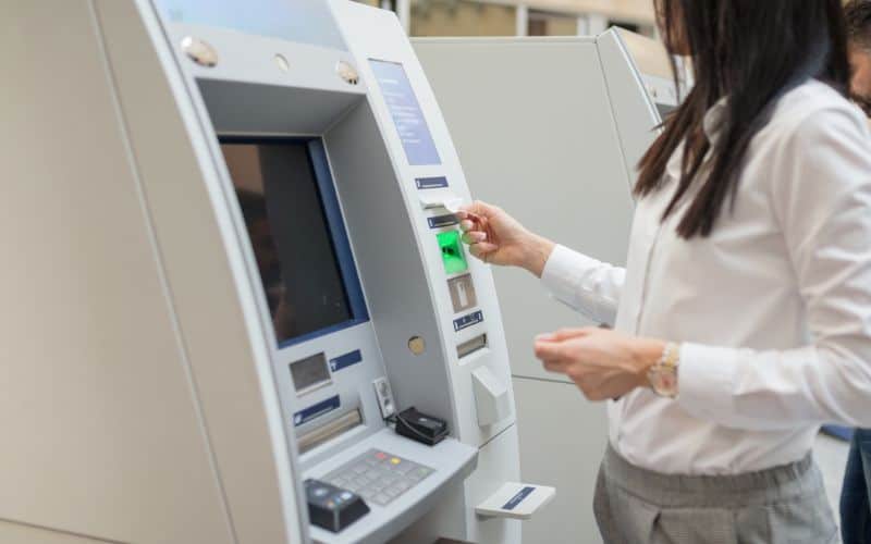 Photo showing a woman getting receipt from ATM