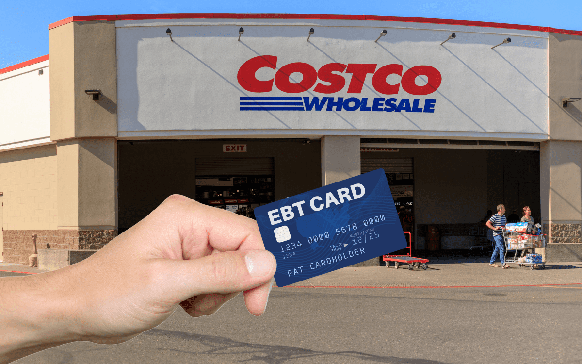 A hand holding EBT card in front of Costco wholesale.